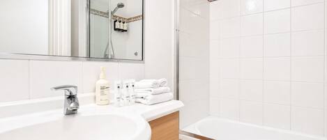 Un baño moderno con un lavamanos grande, un espejo, una ducha y una bañera.