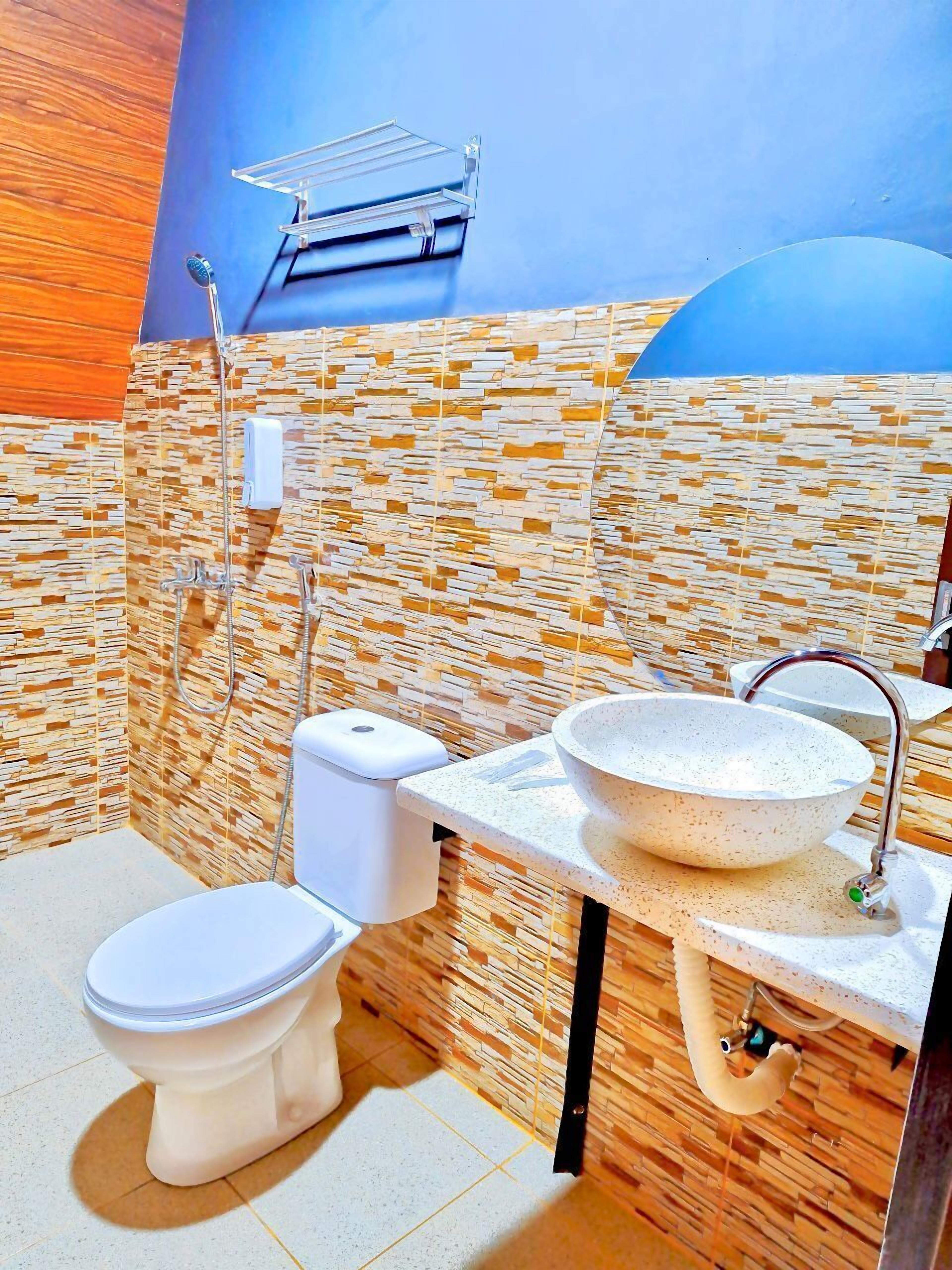 Un baño con inodoro, lavamanos y ducha.