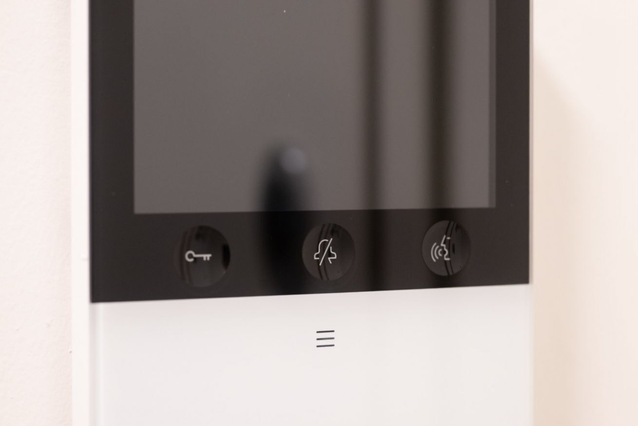 Een bedieningspaneel met drie knoppen, waarvan er één een stroompictogram, een een Wi-Fi symbool en de derde een luidspreker symbool heeft.