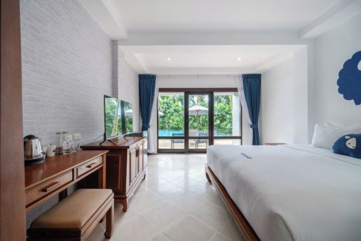Une chambre d’hôtel avec un lit, un bureau avec une télévision et une vue sur l’extérieur.