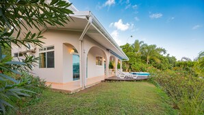 Une maison avec une piscine, entourée d’une végétation luxuriante et d’une pelouse bien entretenue.