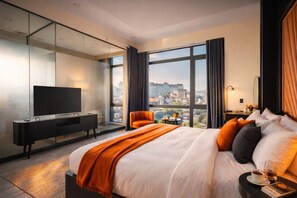A modern hotel room with a large bed, a TV, a seating area, and a city view. - Greenview City Hotel (Xuan Huong - Da Lat)