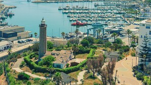 Un port de plaisance abritant de nombreux bateaux, une tour imposante et des bâtiments environnants.