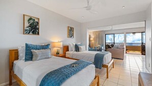 Habitación de hotel con dos camas, un balcón y vistas al cielo.
