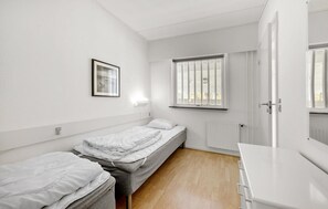 Cozy retreat with a single bed, framed artwork, and a desk for work.