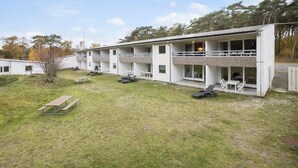 Un edifici modern amb múltiples balcons i un pati enjardinat.