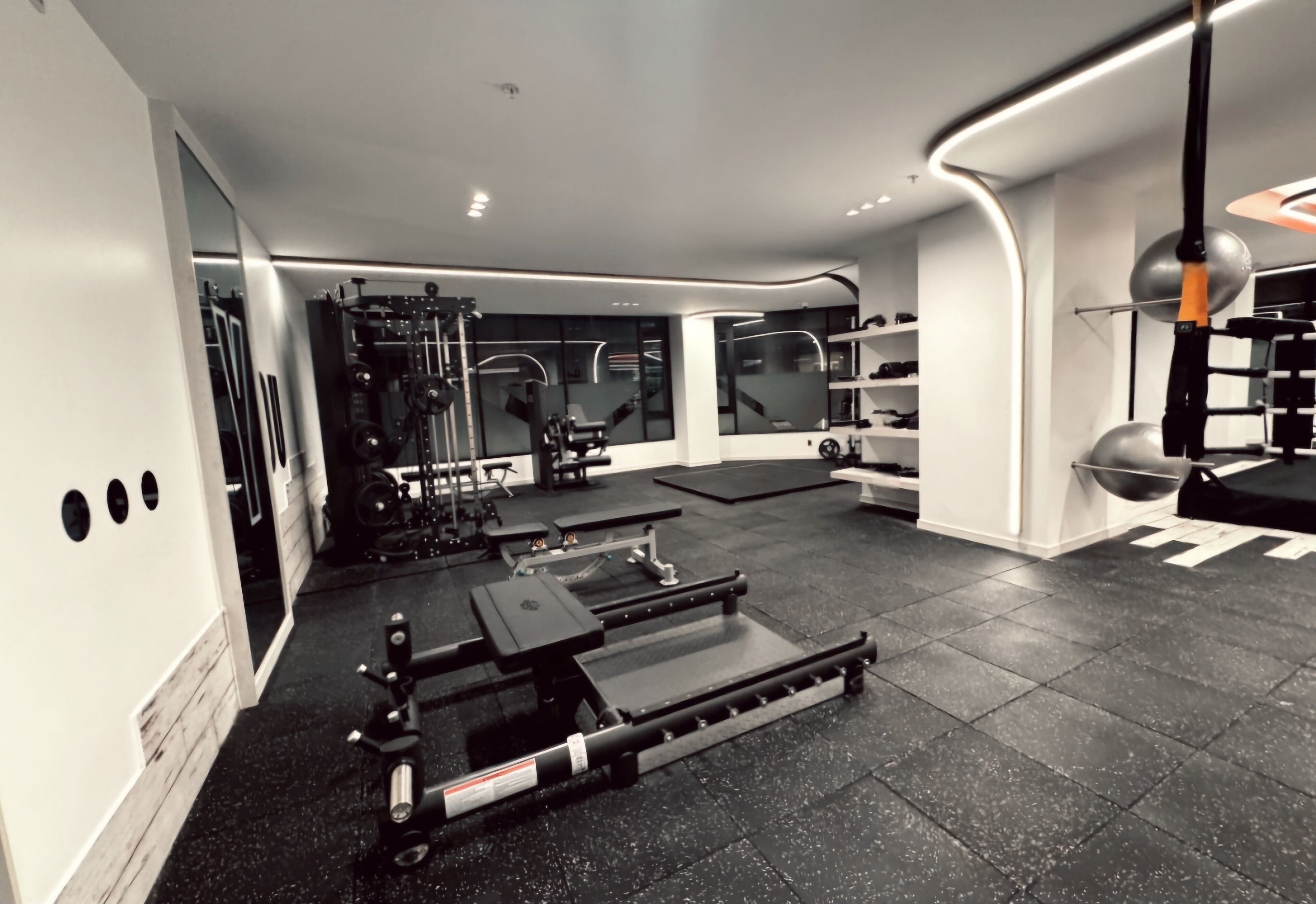 Ein modernes Fitnessstudio mit verschiedenen Trainingsgeräten, darunter Laufbänder und Kraftgeräte.