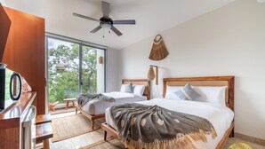 A bedroom with two beds, a ceiling fan, a large window, and a view of greenery outside. - NHOA 311A Lux 2BR Pool View Aldea Zama (Tulum)