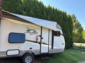 Una autocaravana con un lateral cubierto, un logotipo y una puerta.