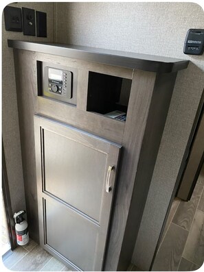 A compact kitchenette with a built-in microwave, a small window, and a door with a handle.