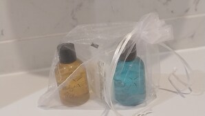 Twee flessen in doorzichtige plastic zakken op een wit oppervlak.