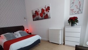 A bedroom with a bed, bedside table, radiator, dresser, and a hanging light fixture. - Apartment T2+ ( sleeps 3 ) (Bagnères de Luchon)