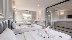 A hotel room with two beds, a sofa, a TV, and a view of the outdoors.