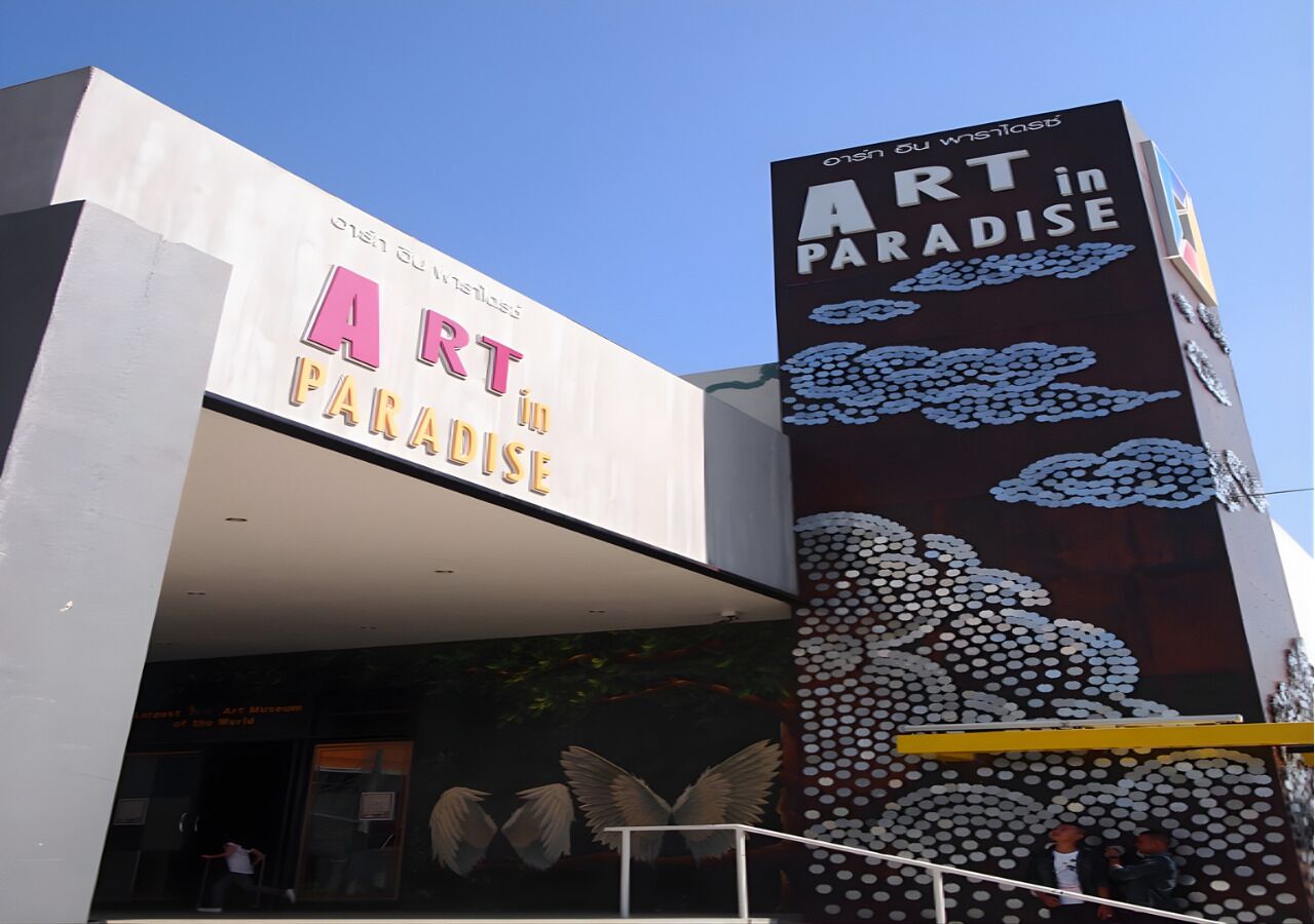 En bygning med et skilt, der siger 'ART in PARADISE'.