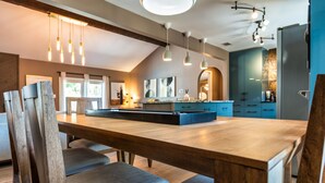 A modern kitchen with a wooden island, pendant lights, and blue cabinets. - Sinatra Fun 5BD Home Huge Pool Game Room (Round Rock)