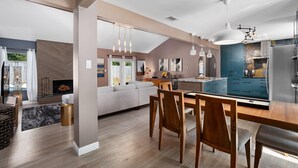 A modern kitchen with a dining area, featuring a large island, pendant lights, and a built-in oven. - Sinatra Fun 5BD Home Huge Pool Game Room (Round Rock)