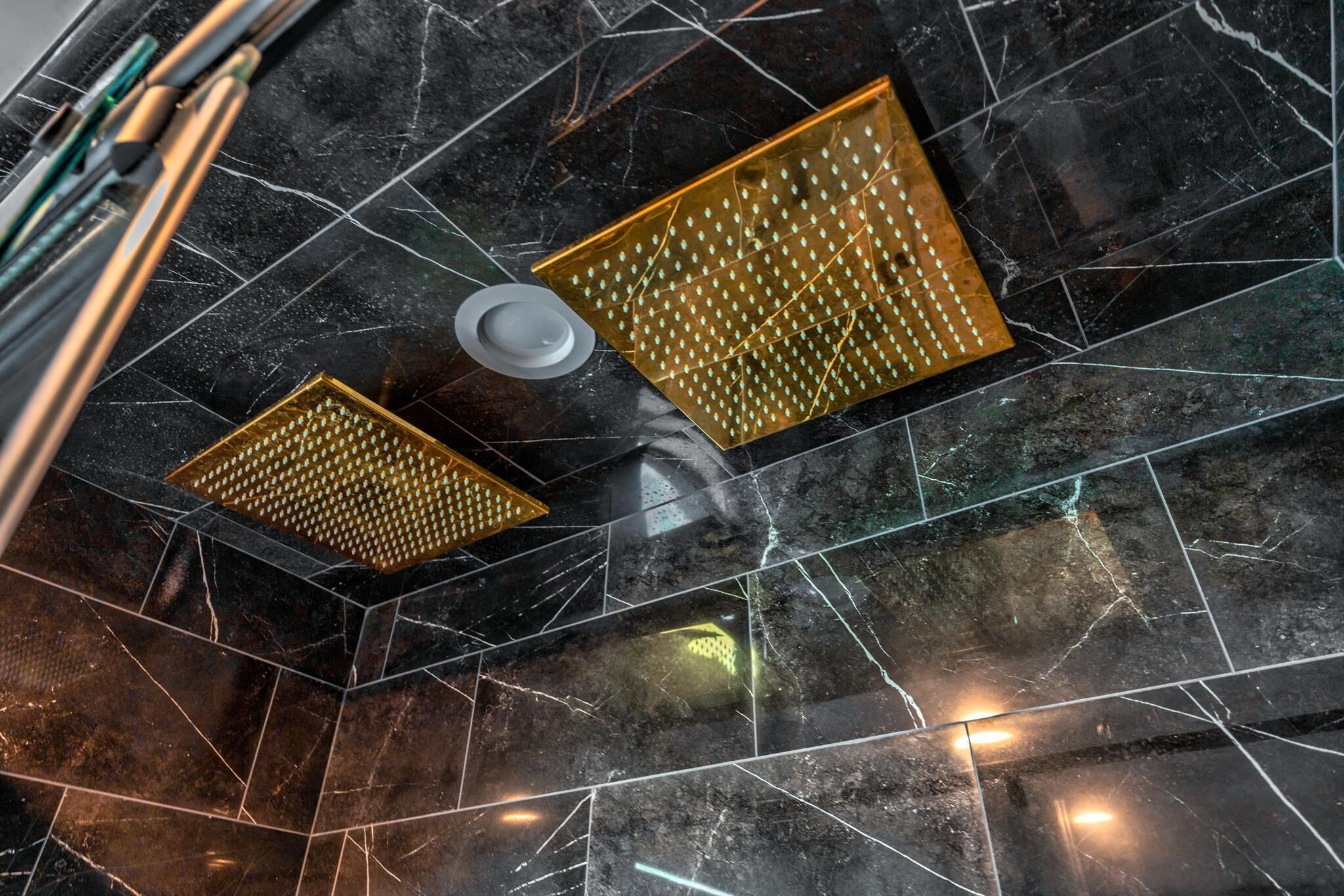 Un suelo de mármol con un diseño geométrico y un techo con dos rejillas de ventilación.