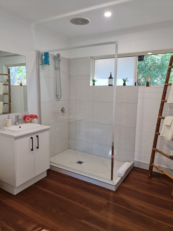 Een douche, handdoeken, zeep, toiletpapier