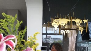 A reception desk with a receptionist, a world map decoration, and blue vases with flowers. - ArisSha Boutique Hotel (Cali)
