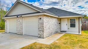 A single-story house with a garage, brick exterior, and a small front porch.