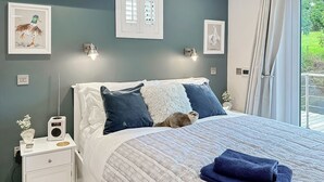 Una camera da letto con un letto, comodini, una radio e opere d'arte alle pareti.
