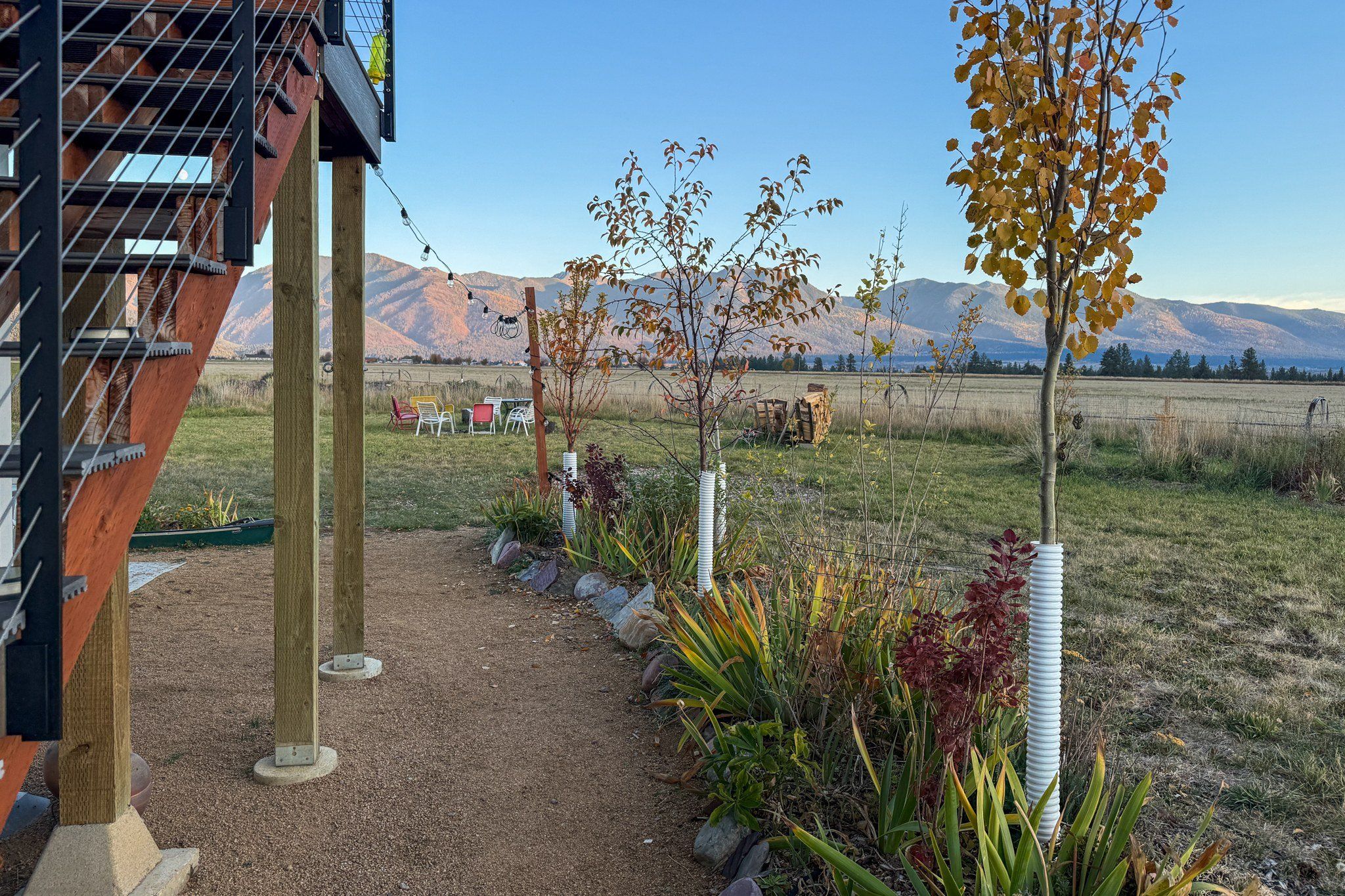 A garden with a gravel path, plants, and a view of mountains.