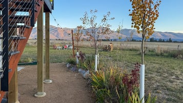 A garden with a gravel path, plants, and a view of mountains.