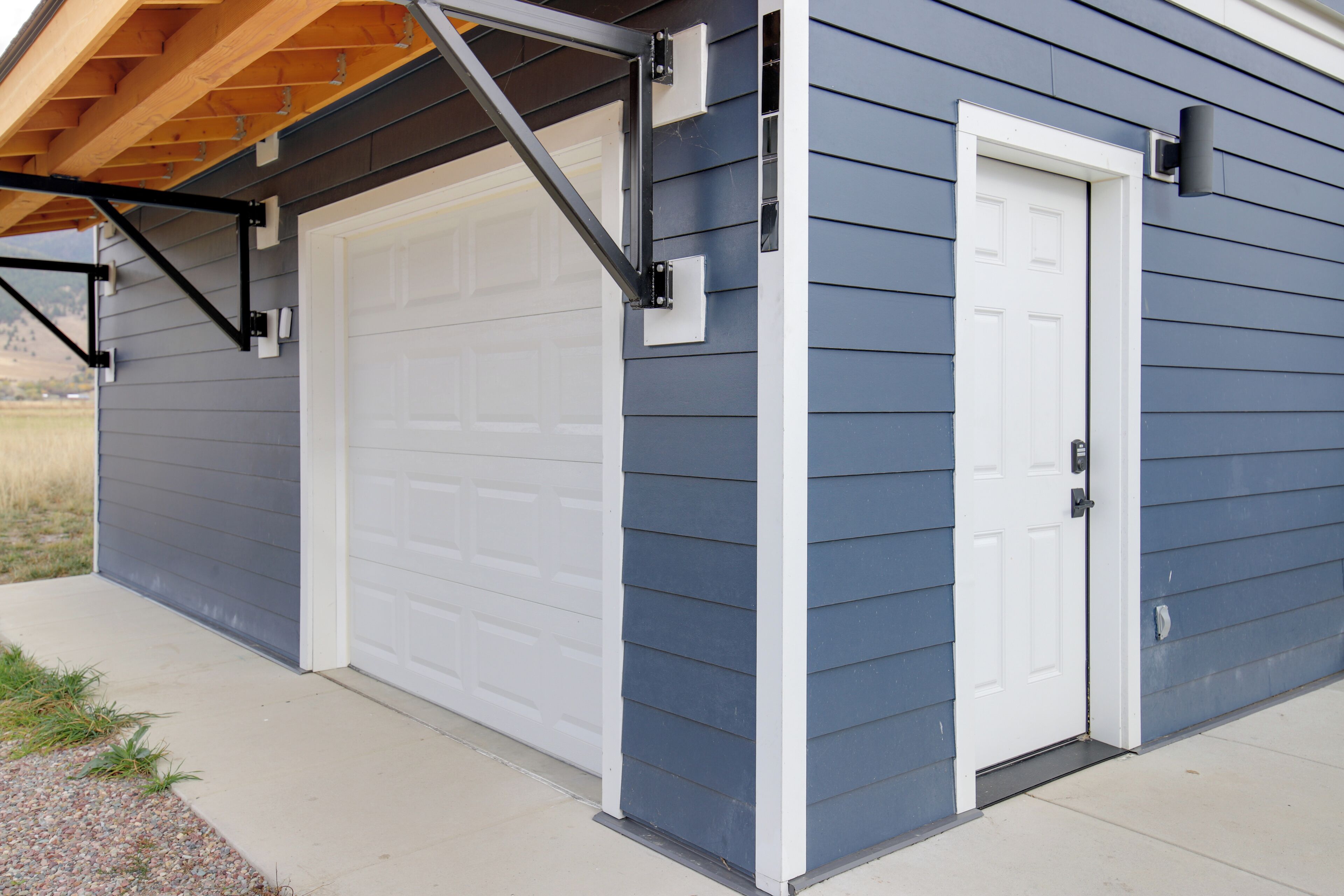 A garage with a white door and a small white door next to it.