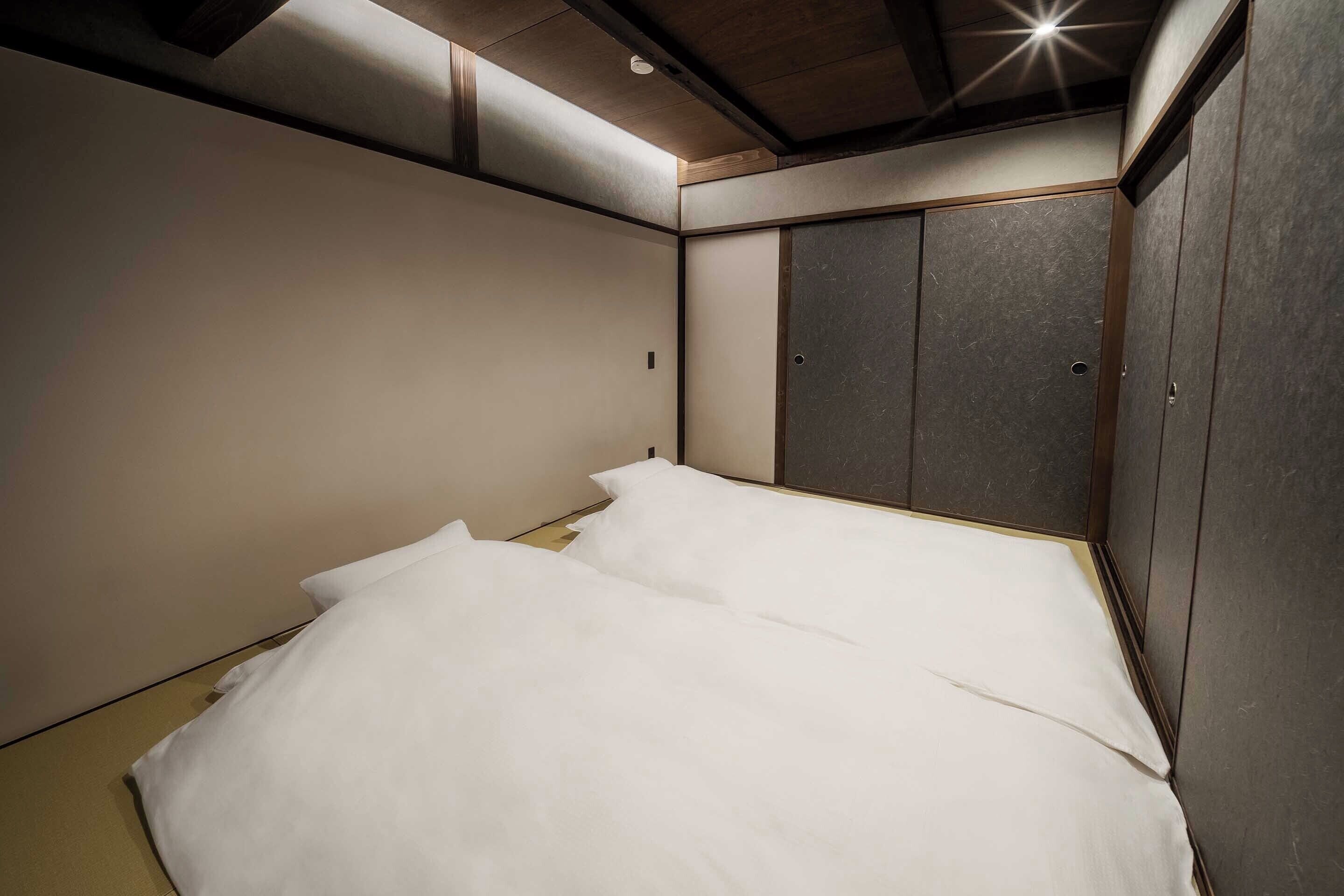 Una habitación con cama, armario y lámpara en el techo.