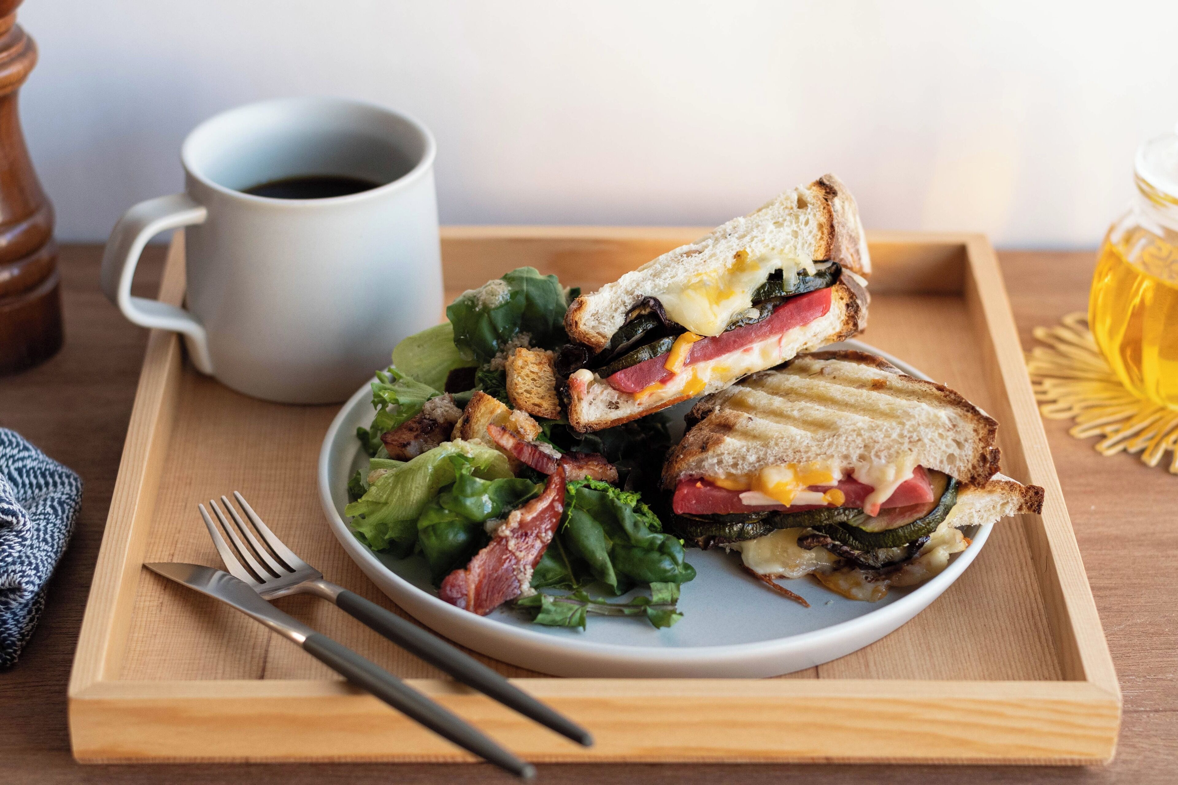 A meal tray with a sandwich, salad, and a cup of coffee.