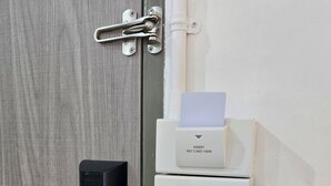 A door with a modern lock, a card reader, and a wall-mounted intercom system. - Charm Hostel at Jomtien (Pattaya)