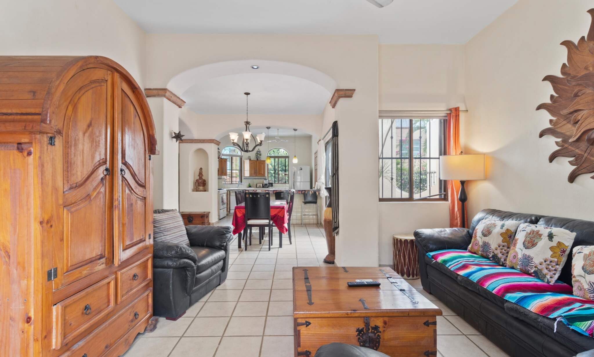 A spacious living room with a sofa, a coffee table, and a wooden cabinet.