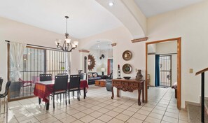 A spacious living area with a dining table, chairs, a sofa, and a coffee table. - Casa Sandy - Private Golden Zone Villa with Pool (Bucerías)