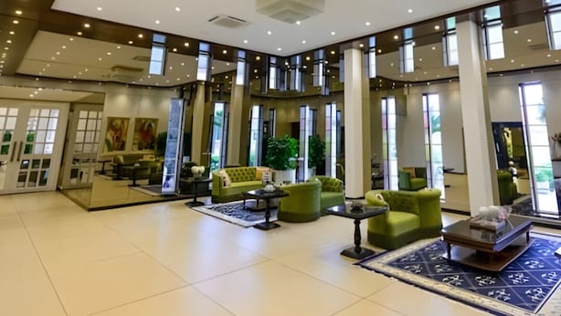Un hall d’entrée spacieux, doté de hauts plafonds, de grandes fenêtres et de mobilier moderne.