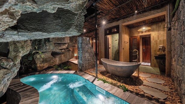 A spa area with a hot tub, a stone wall, and a pool. - Chay Mountain Retreat Ninh Binh (Hoa Lu)