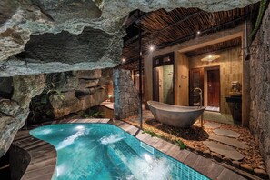 A spa area with a hot tub, a stone wall, and a pool. - Chay Mountain Retreat Ninh Binh (Hoa Lu)