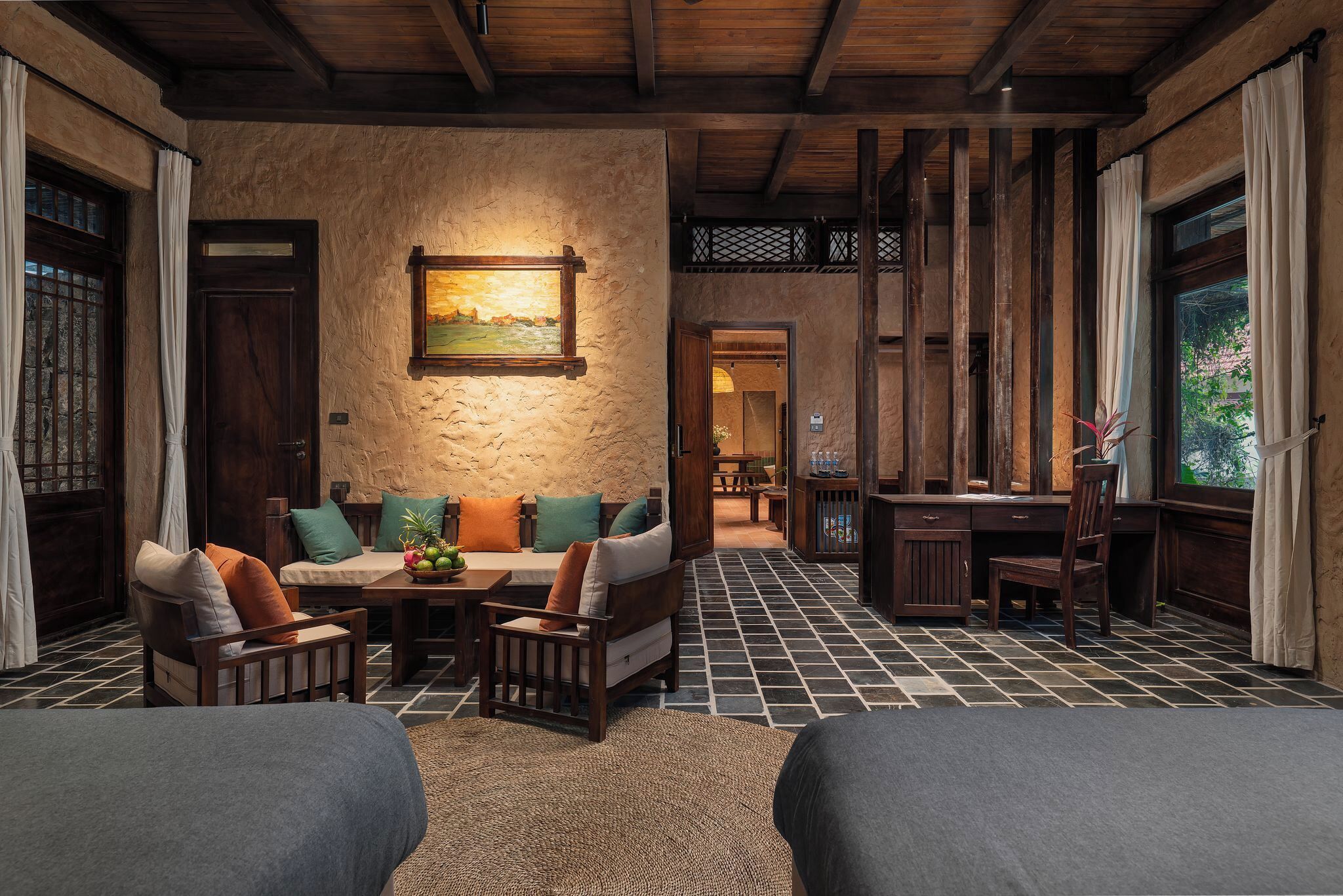 A cozy room with a stone wall, wooden furniture, and a painting.
