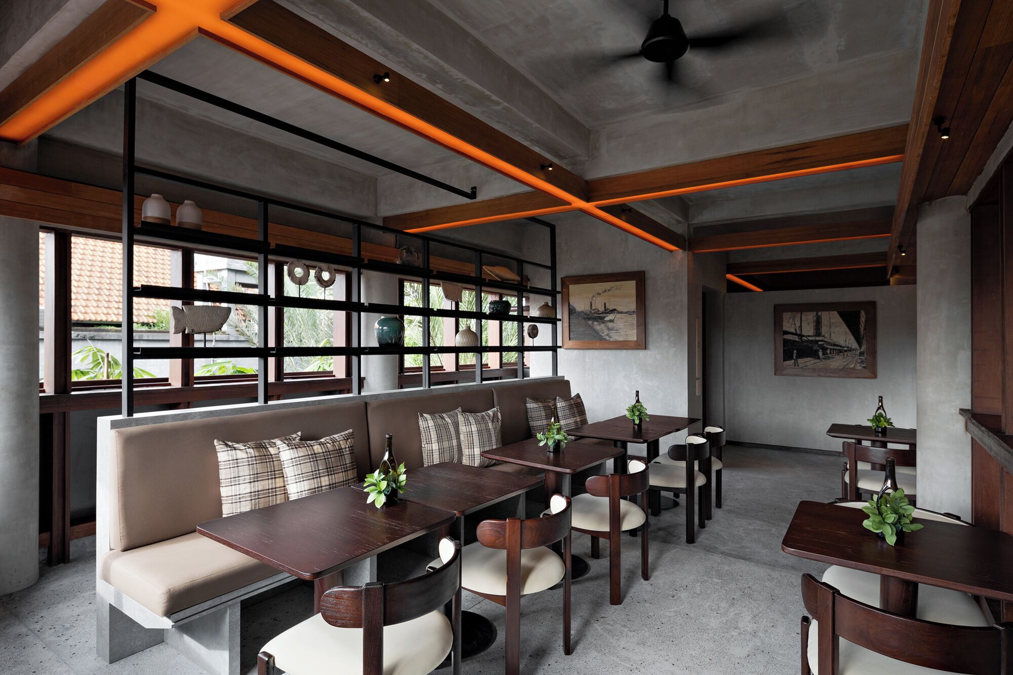 Un intérieur moderne offrant différents types de sièges, notamment un canapé et des tables, et donnant sur l’extérieur grâce à de grandes fenêtres.