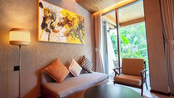 A modern room with a sofa, a chair, a table, and a painting on the wall.