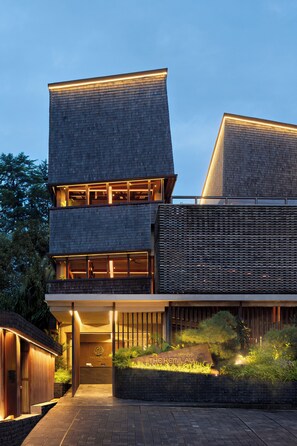 A modern hotel with a two-story structure, large windows, and a well-lit entrance. - The Kemilau Ubud (Ubud)