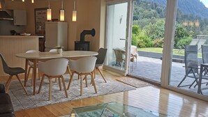 Een moderne keuken met een eethoek, een glazen deur naar een terras met stoelen.