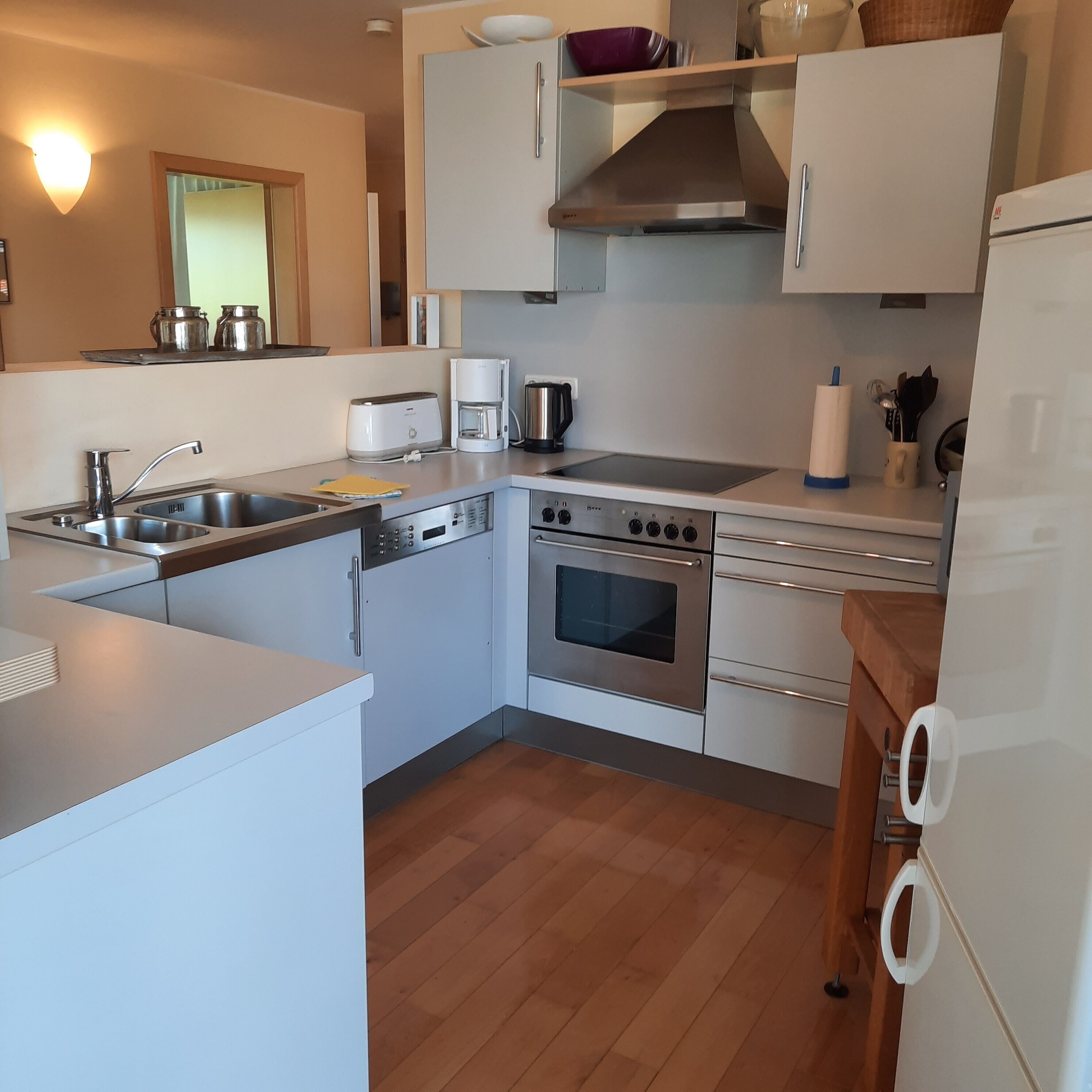 A compact kitchen with a sink, stove, oven, and a coffee maker.