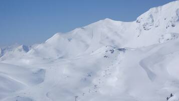 A snow-covered mountain with ski trails.