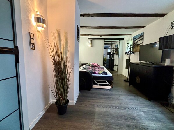 A bedroom with a bed, a dresser, and a television.