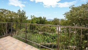 A balcony with a metal railing overlooking a lush garden and distant mountains. - Beautiful apartment in Vinjani Donji with WiFi (Vinjani Donji)