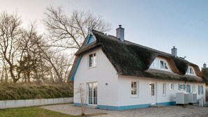 A traditional house with a thatched roof, white walls, and blue trim. - Holiday Home Mühlenperle with Private Terrace, Garden, Sauna & Parking, Baltic Sea, Stove (Boiensdorf OT Stove)
