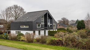 A modern two-story house with a sloped roof, a visible staircase leading to the upper floor, and a front porch. - Apartment 'Haus Erika' with Shared Terrace, Shared Garden and Wi-Fi (Brunsbüttel)