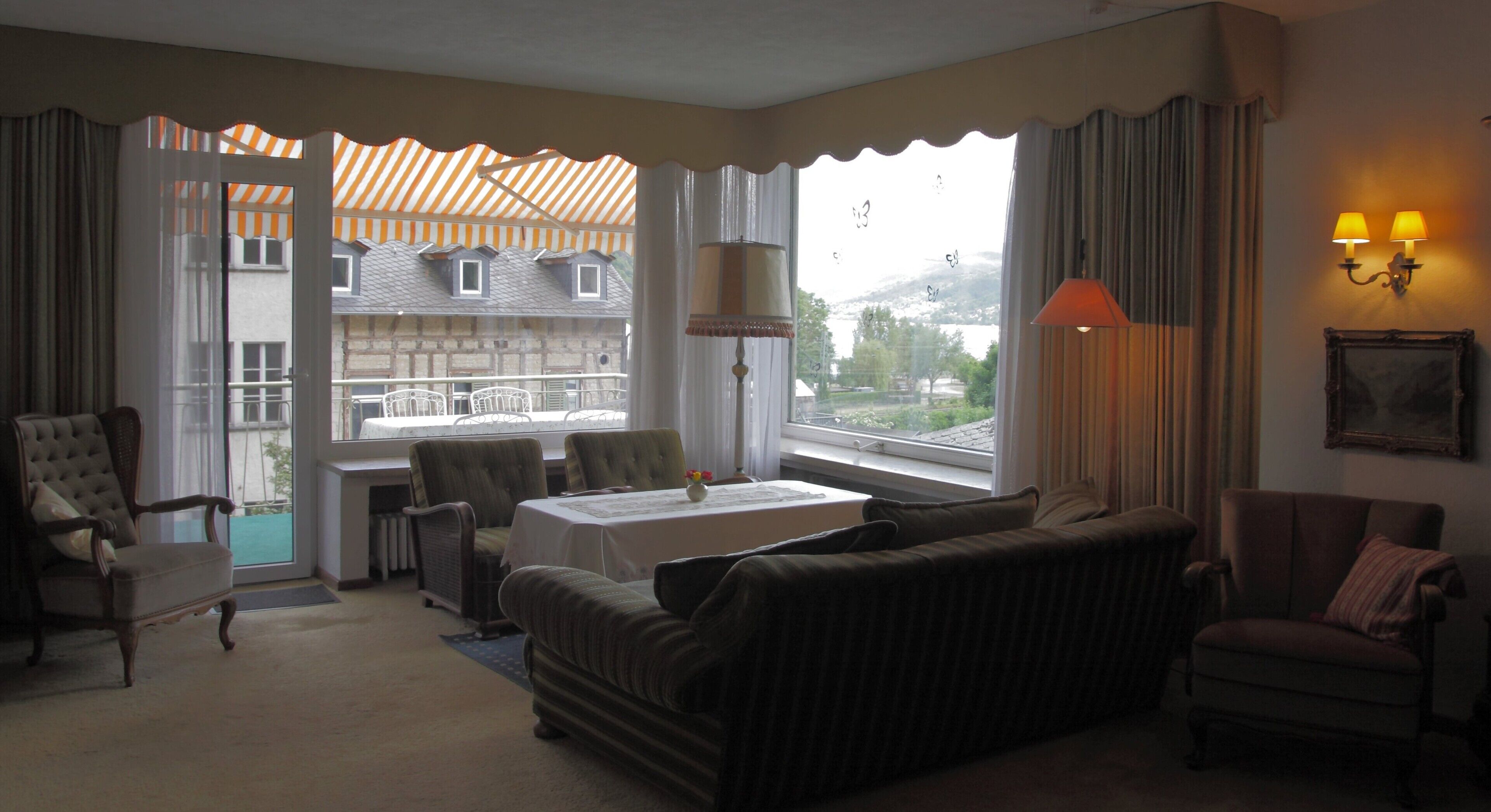 Een hotelkamer met uitzicht, een eettafel, een bank en een stoel.