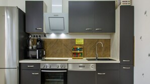 Una cocina equipada con refrigerador, estufa, horno, microondas y cafetera.