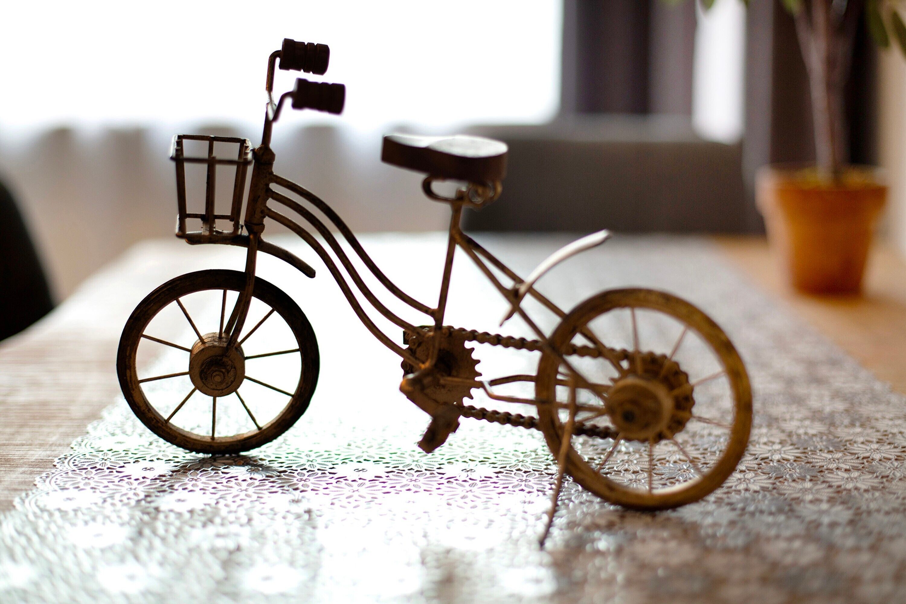 Un vélo avec un panier et une selle posée sur une surface texturée.
